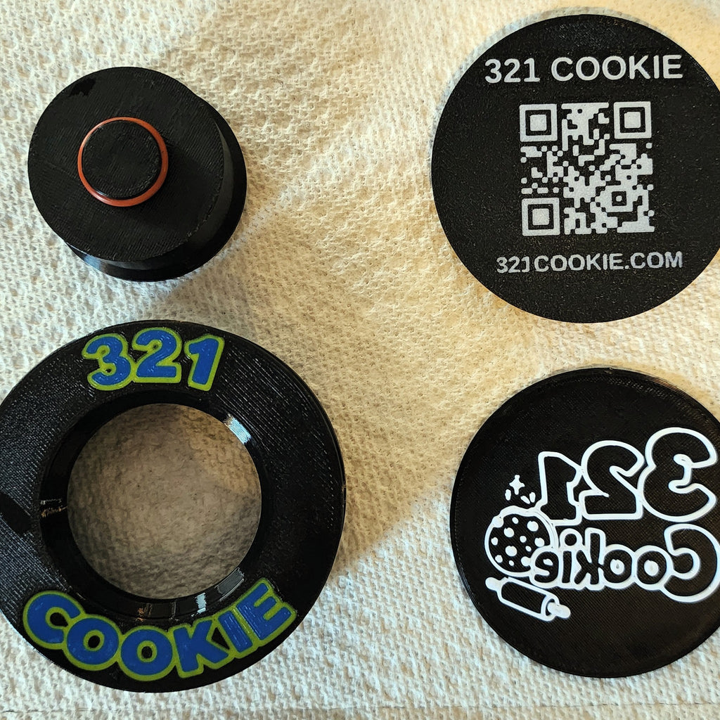 Press parts and a design disc drying on a paper towel after washing