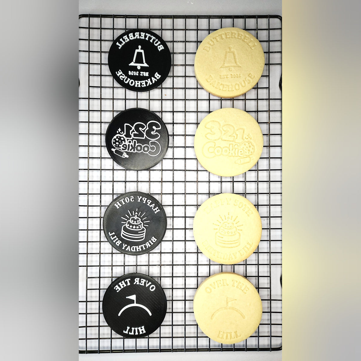 Logo and design discs beside the real cookies they stamped, including a bakery logo
