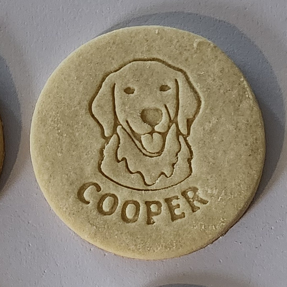Cooper the dog's face and name stamped into a real baked sugar cookie