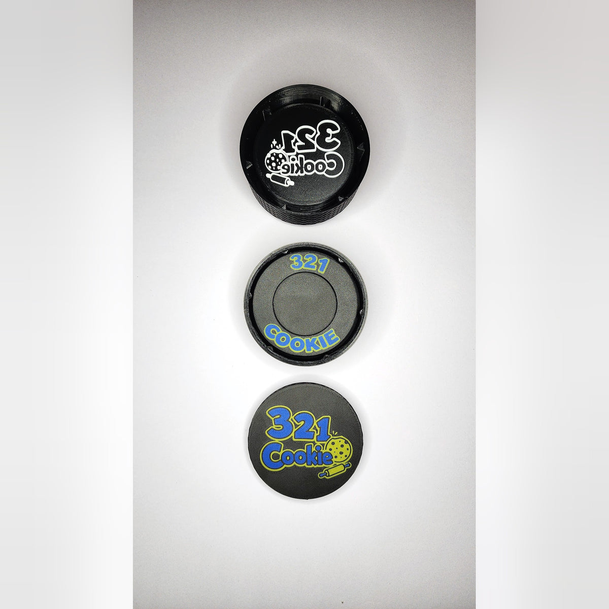 The three Storage Stack parts lined up from above: the 12-disc case, the press case and the full-color logo lid