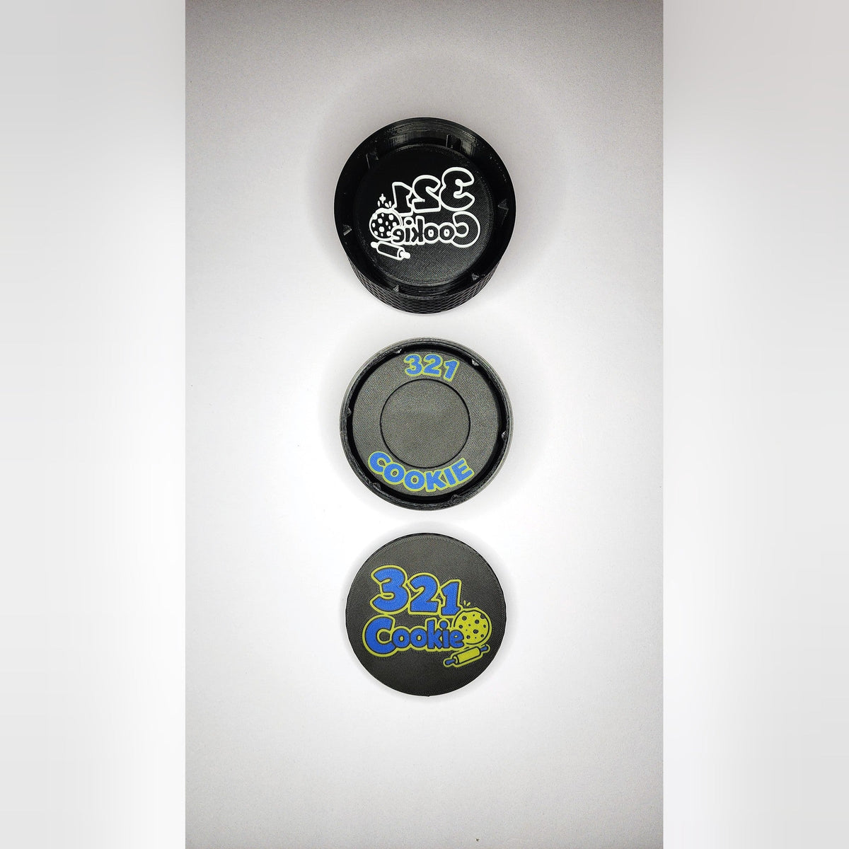 The Storage Stack parts lined up from above: the 12-disc case, the press case and the full-color logo lid